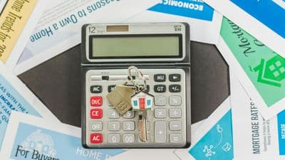 Calculator with house keys on mortgage rate documents